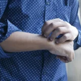 seorang pria sedang menggaruk tangan